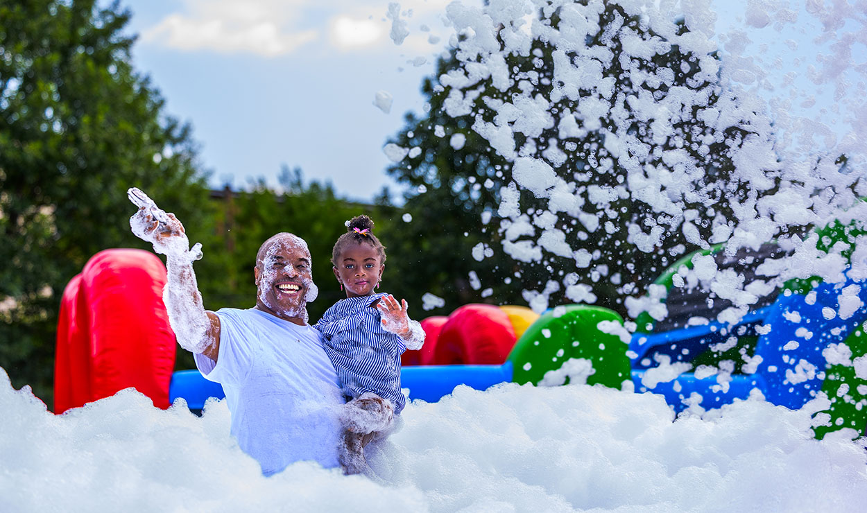 Approximately 250 residents, families and friends from the neighborhood enjoyed bounce houses, a water slide, foam bubbles, various games, face painting, food, live music and more. Children in attendance were thrilled to see Woody from the Toy Story movies at the party. Attendees were able to connect and enjoy the day together, further strengthening community bonds.