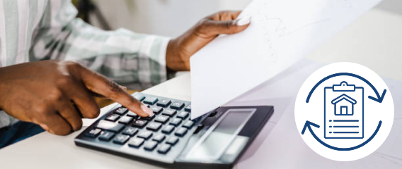 A person doing paperwork and typing on a calculator