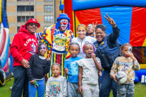 A DCHA family and event staff smile for an outdoor group photo during the Potomac Gardens Community Day celebration.